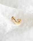 14 Carat gold flat moon and star thread labret piercing shown on silk background