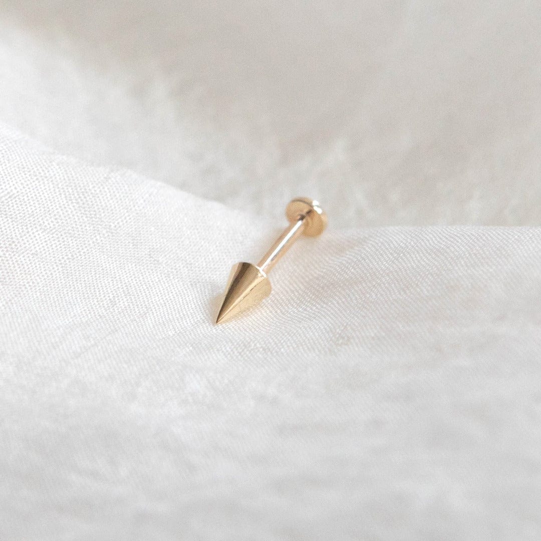 14 Carat Solid yellow Gold 5mm Spike Labret Piercing shown on silk background