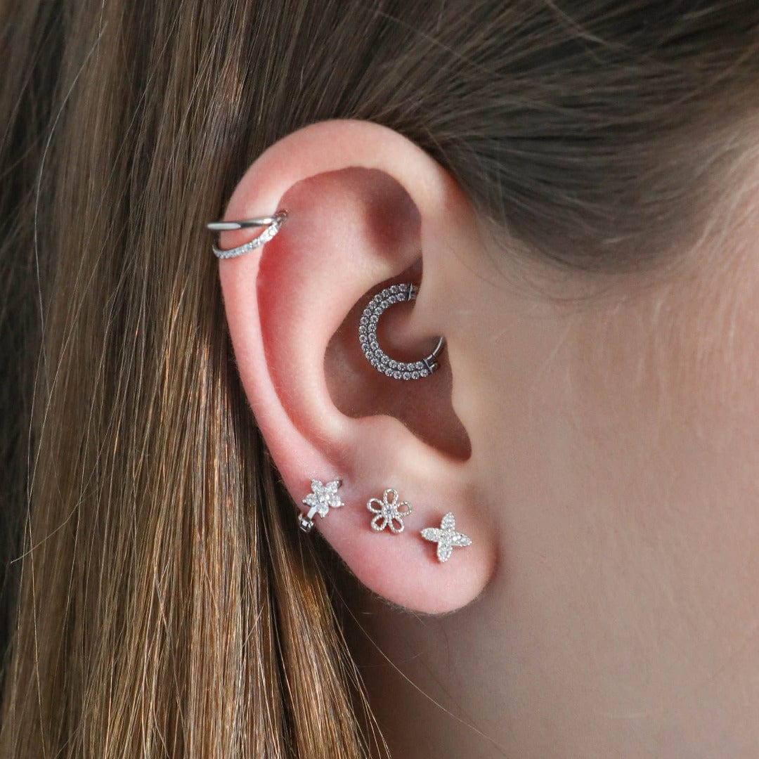 Criss Cross barbell piercing with screw ball back in silver shown on model with mutliple lobe piercings